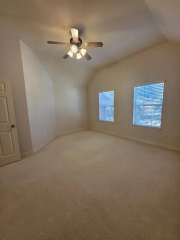 a view of an empty room with a chandelier fan