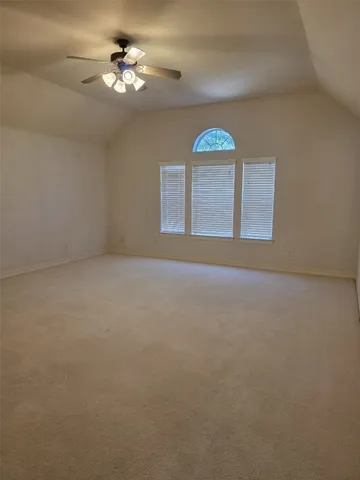 en empty room with windows and ceiling fan
