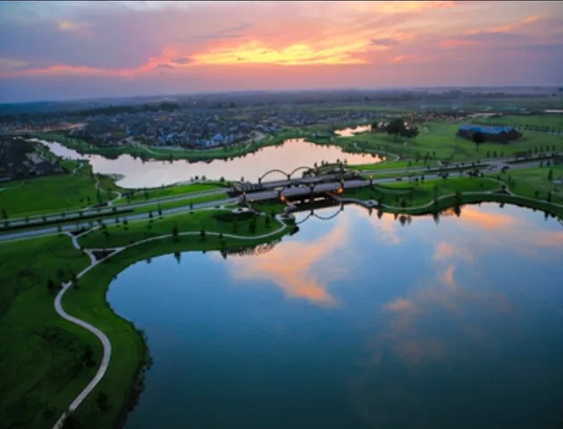 a view of a lake with houses in back
