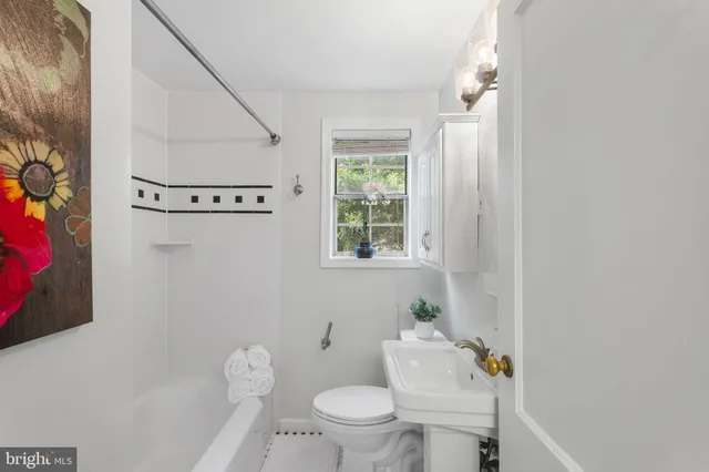 a white toilet sitting next to a bathroom sink and tub