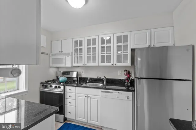 a kitchen with a refrigerator and a stove top oven