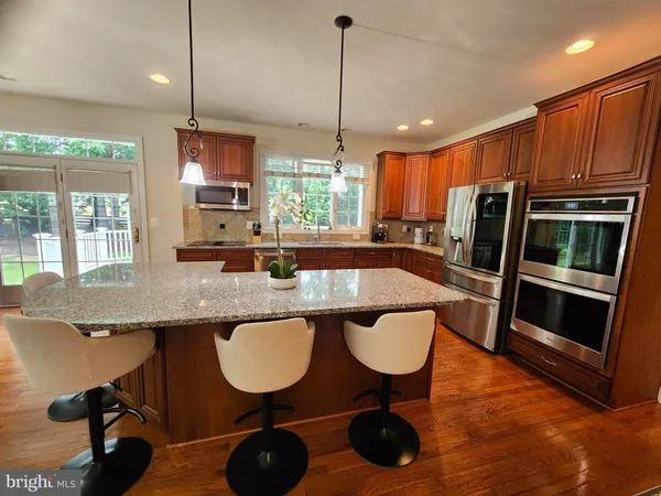 a kitchen with stainless steel appliances granite countertop sink microwave and wooden floor