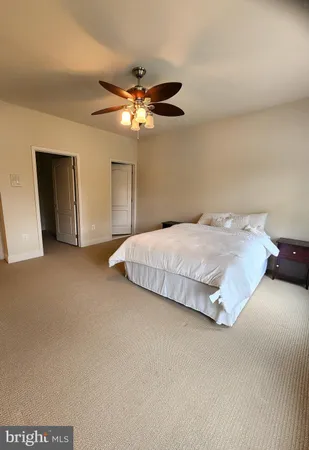 a bedroom with a bed and a ceiling fan