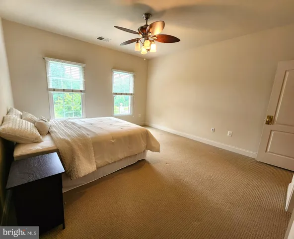 a bedroom with a bed and a ceiling fan