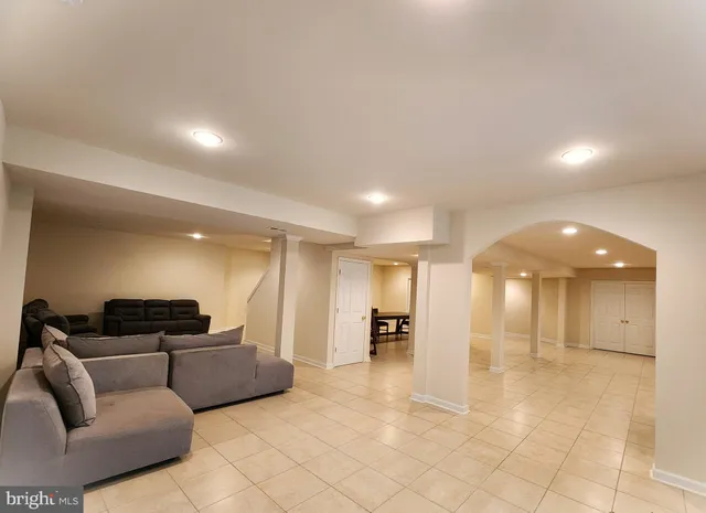 a view of a hallway with wooden floor and a bathroom