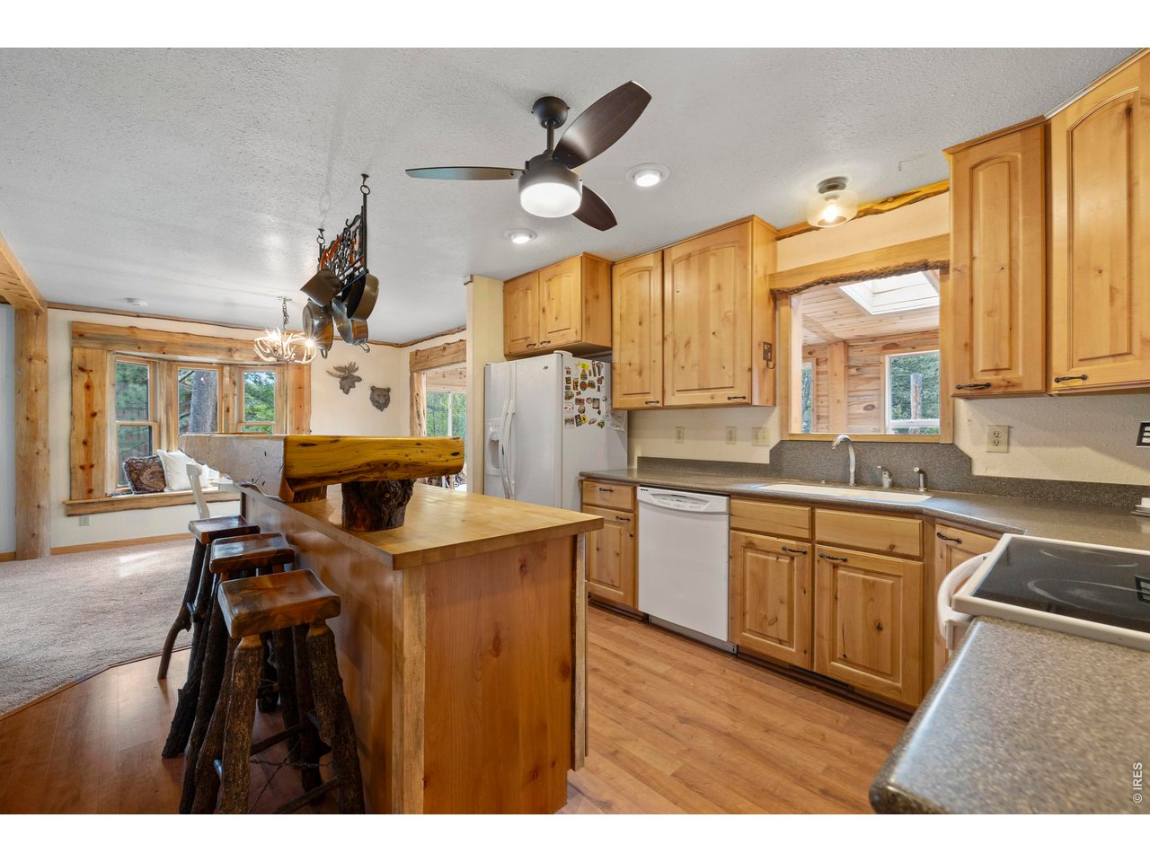 428 Rustic Road Bellvue, CO 80512 - Photo 13 of 43 a open kitchen with stainless steel appliances kitchen island granite countertop a sink cabinets and wooden floor