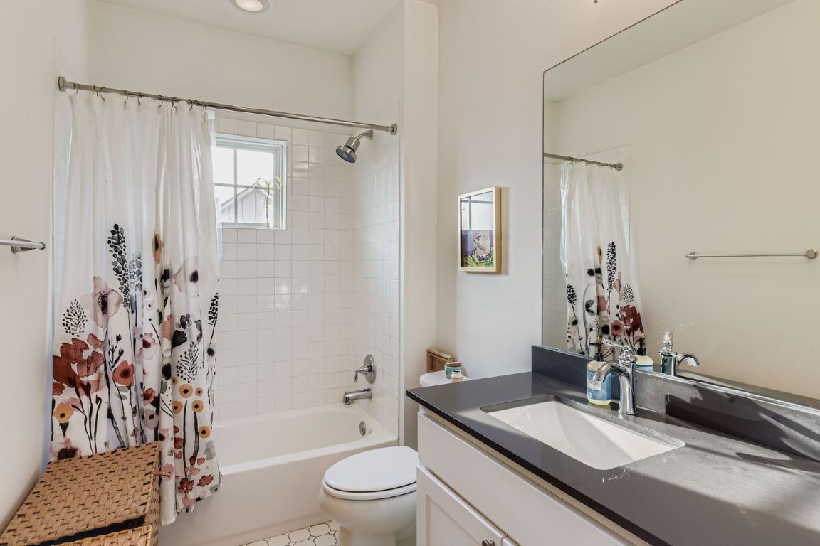1213 Eleanor Street, Unit B Austin, TX 78721 - Photo 12 of 17 a bathroom with a granite countertop sink a toilet and shower