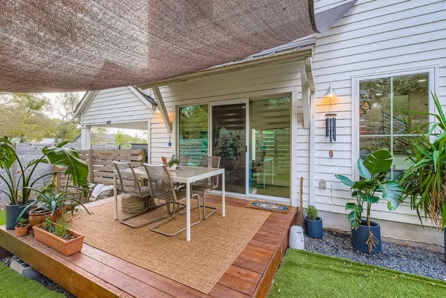 a view of a patio with table and chairs potted plants with floor to ceiling window and wooden floor