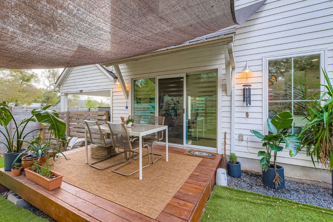 1213 Eleanor Street, Unit B Austin, TX 78721 - Photo 15 of 17 a view of a patio with table and chairs potted plants with floor to ceiling window and wooden floor