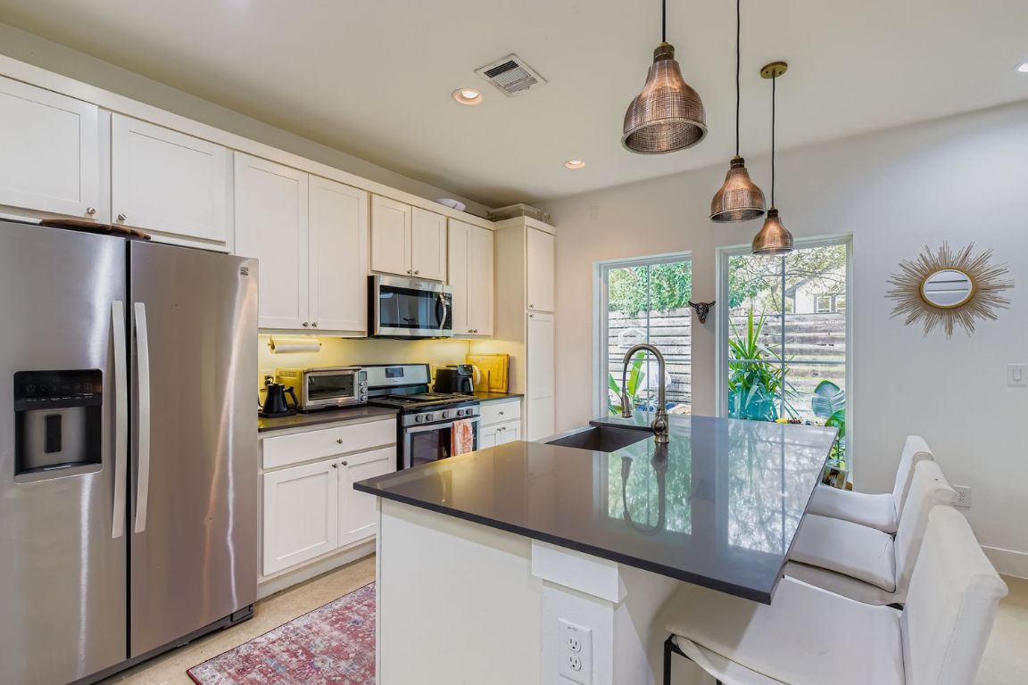 1213 Eleanor Street, Unit B Austin, TX 78721 - Photo 7 of 17 a kitchen with refrigerator cabinets and furniture