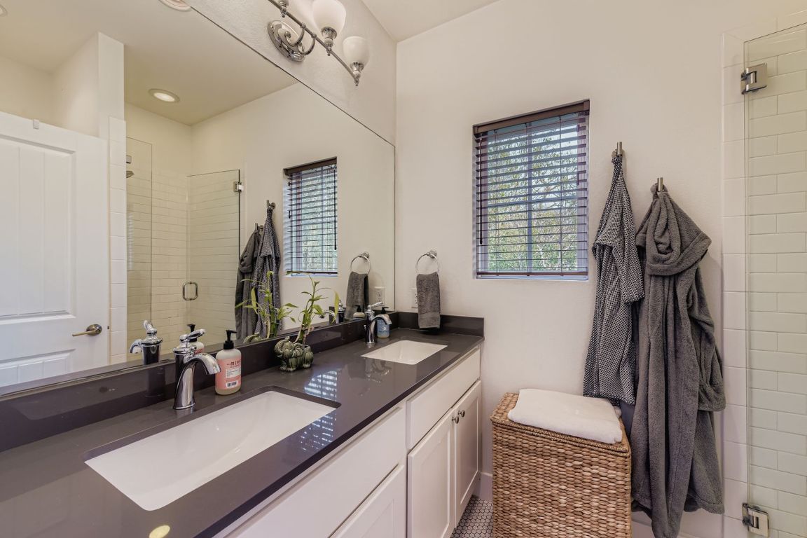 1213 Eleanor Street, Unit B Austin, TX 78721 - Photo 10 of 17 a bathroom with a double vanity sink a mirror and a bathtub