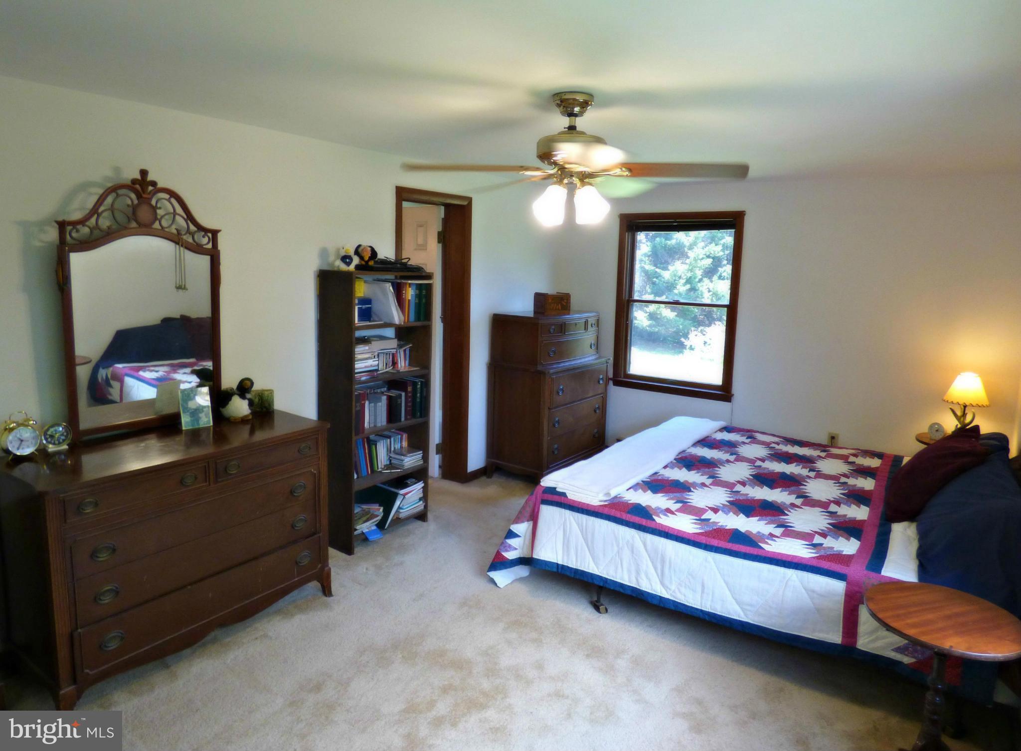 8409 Mapleville Road Mount Airy, MD 21771 - Photo 14 of 30 a bedroom with a bed and a chandelier