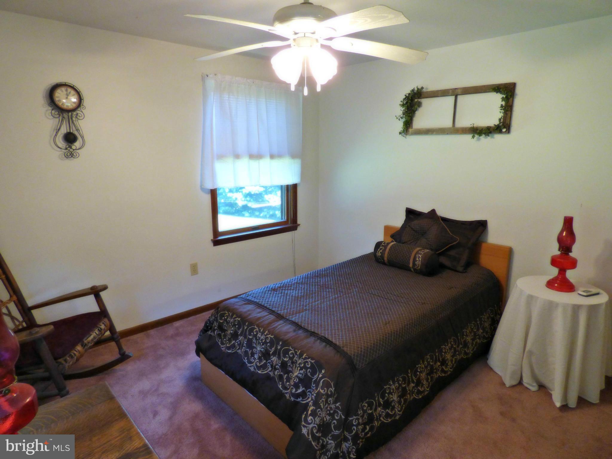 8409 Mapleville Road Mount Airy, MD 21771 - Photo 15 of 30 a bedroom with a bed and a chandelier