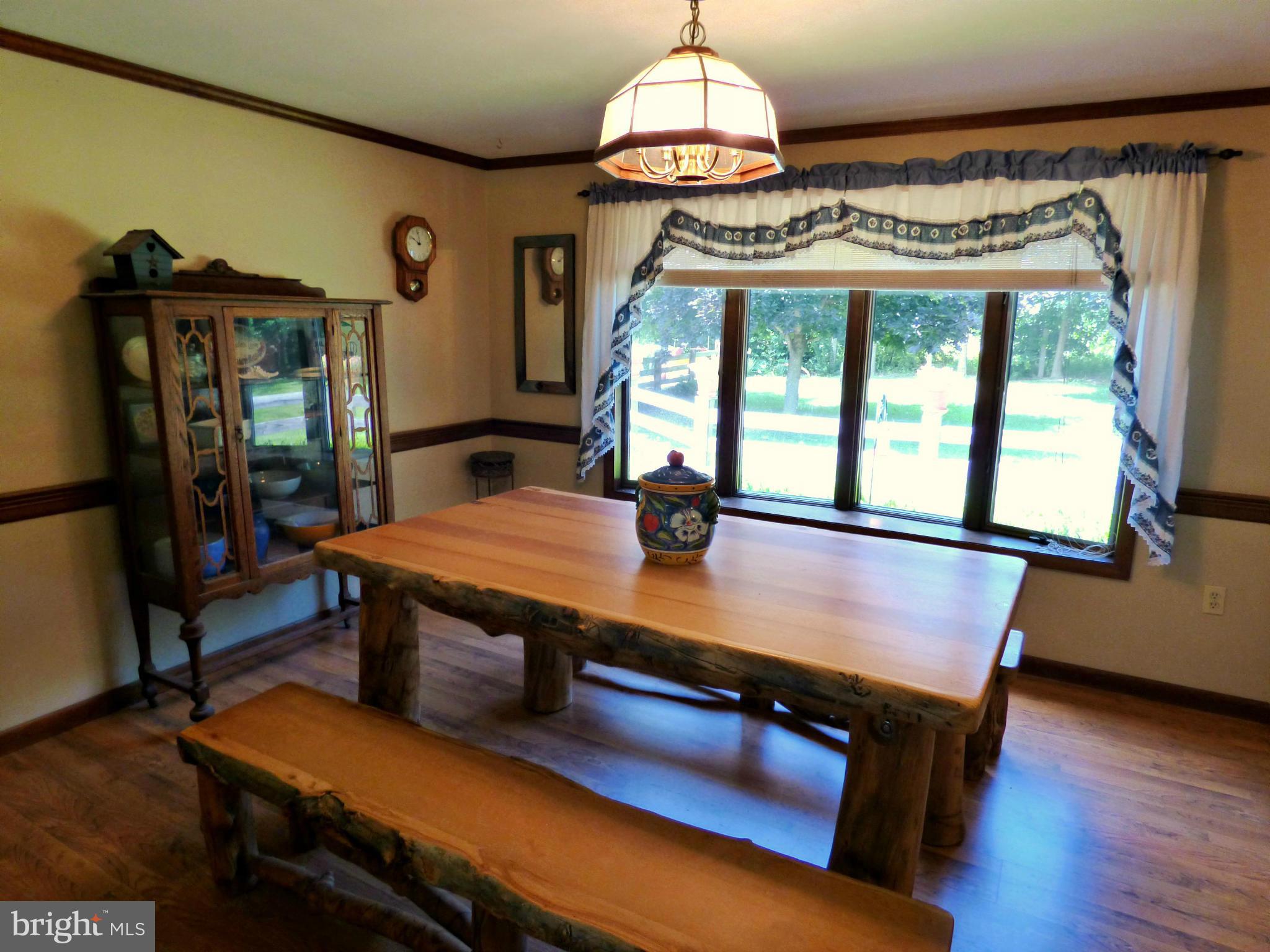 8409 Mapleville Road Mount Airy, MD 21771 - Photo 3 of 30 a dining room with furniture a chandelier and wooden floor