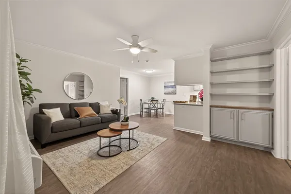 a living room with furniture white walls and wooden floor