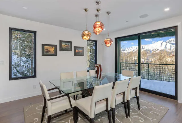 a view of a dining room with furniture a chandelier and a large window