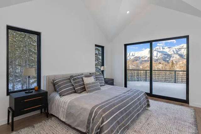 a bedroom with a large bed and a balcony view