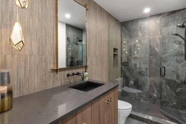 a bathroom with a double vanity sink toilet and shower
