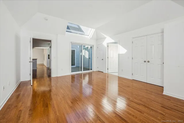a view of a big room with wooden floor and windows