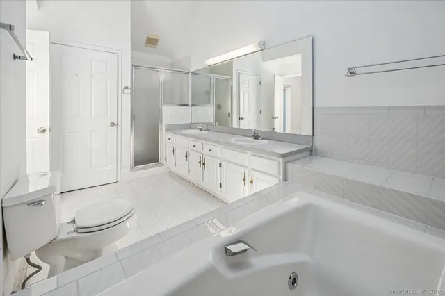 a bathroom with a tub sink and a mirror