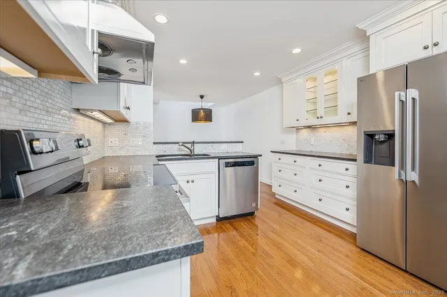 a kitchen with stainless steel appliances granite countertop a stove a sink and a refrigerator