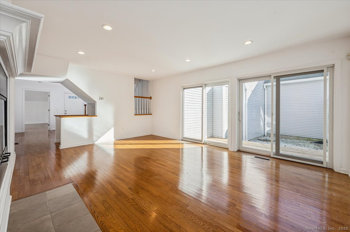 66 Wilton Crest Road, Unit 66 Wilton, CT 06897 - Photo 7 of 25 a view of an empty room with wooden floor and a window