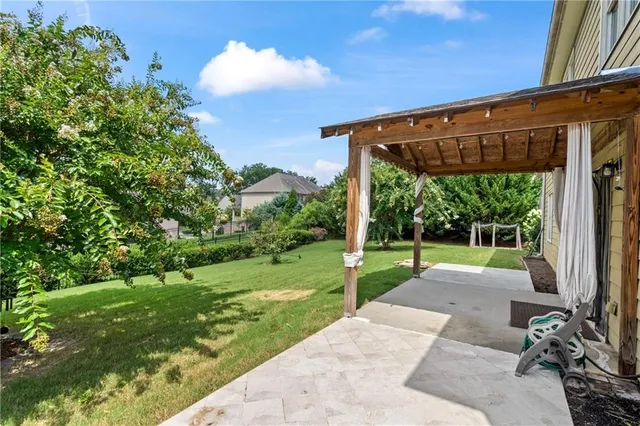 a view of a backyard with couches plants and large tree