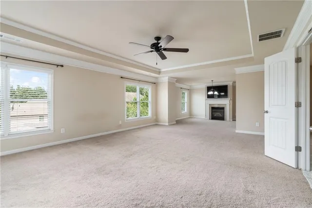 an empty room with windows and ceiling fan