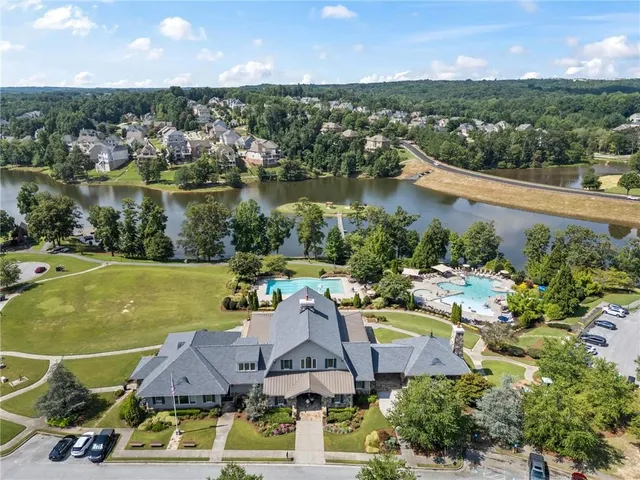 an aerial view of residential houses with outdoor space and lake view