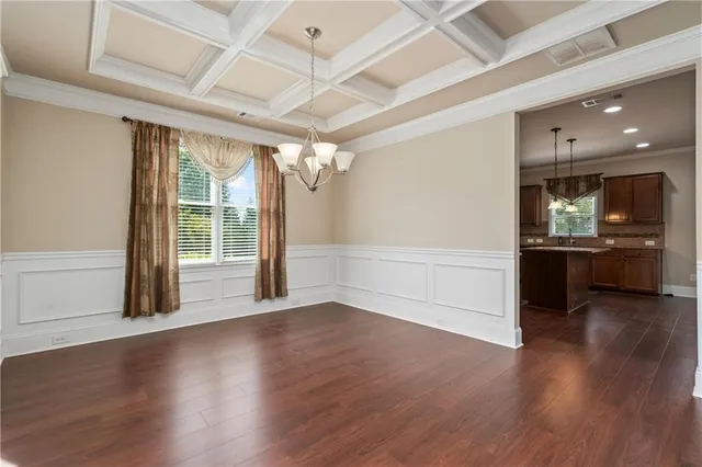 a view of a big room with wooden floor and windows