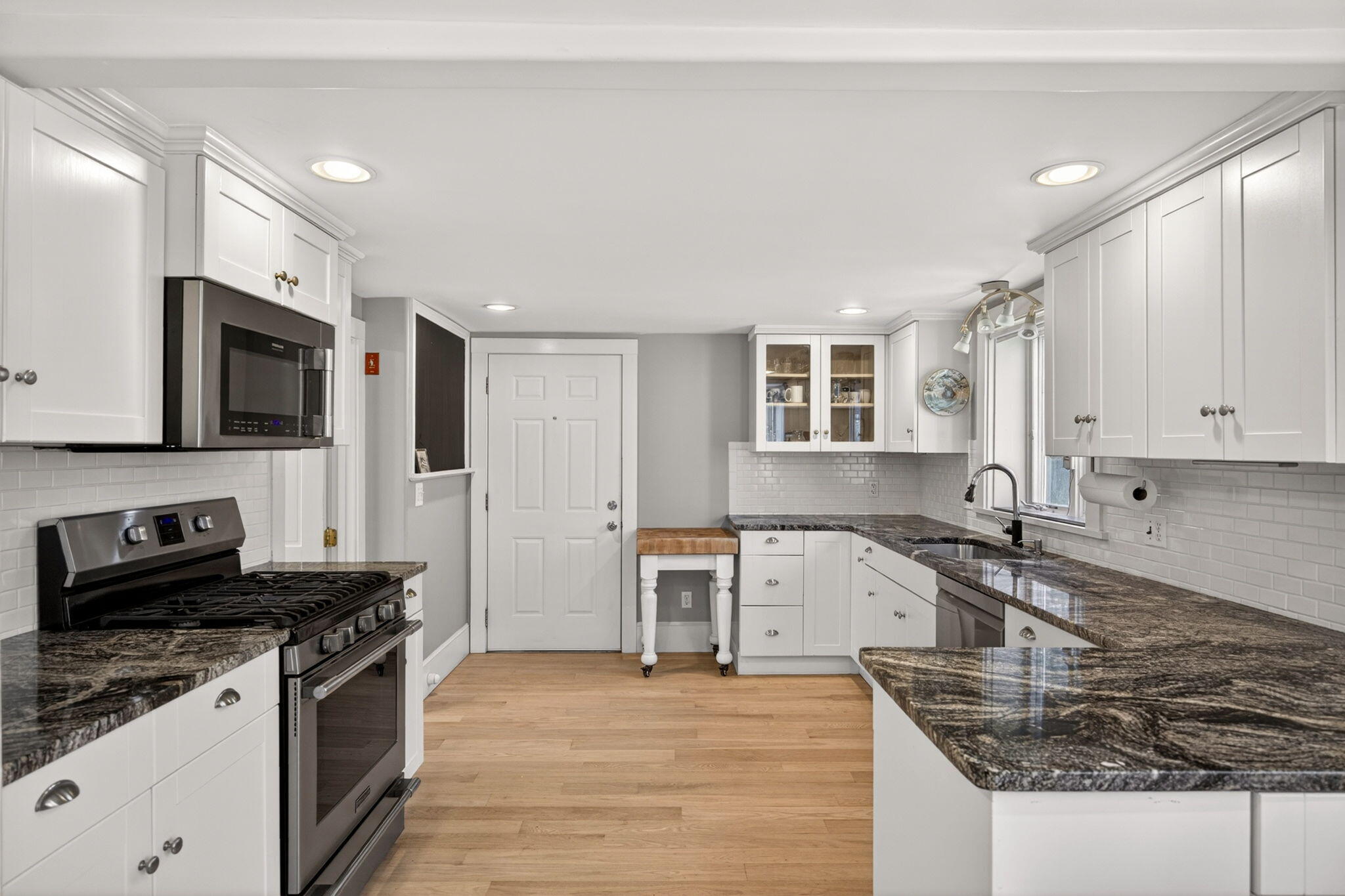 69 County Road Bourne, MA 02532 - Photo 10 of 54 a kitchen with granite countertop a sink a stove top oven and cabinetry