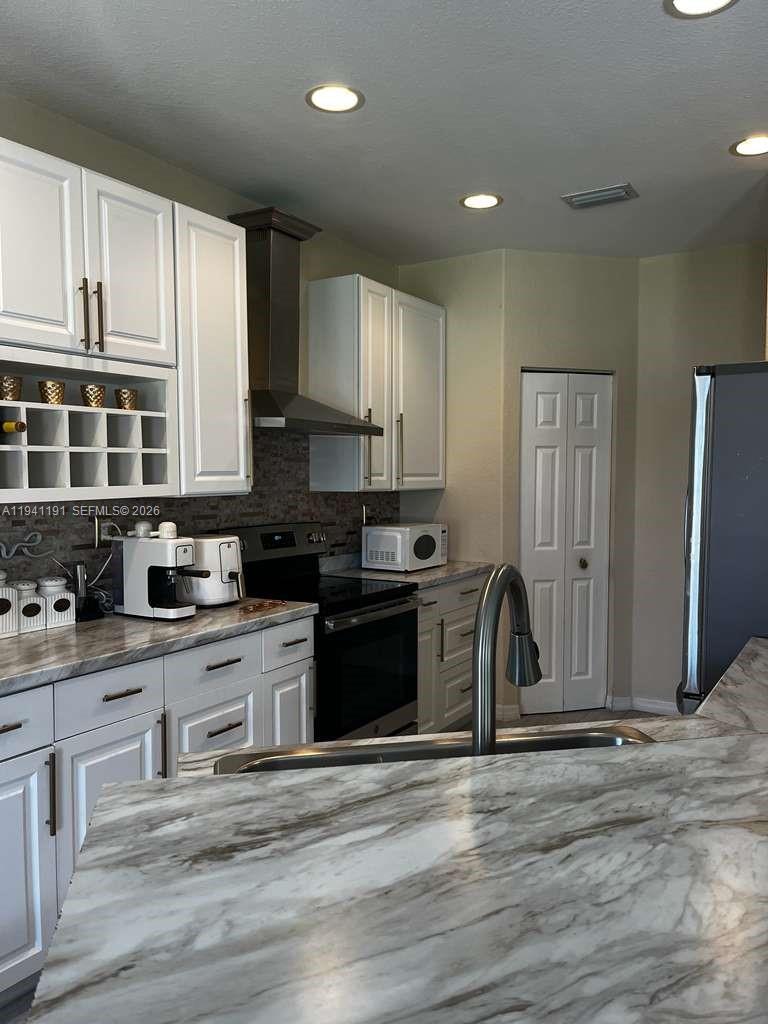 1531 Southeast 20th Road Homestead, FL 33035 - Photo 2 of 10 a kitchen with stainless steel appliances granite countertop a stove a sink and a refrigerator