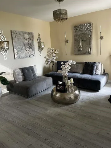 a living room with furniture and a chandelier