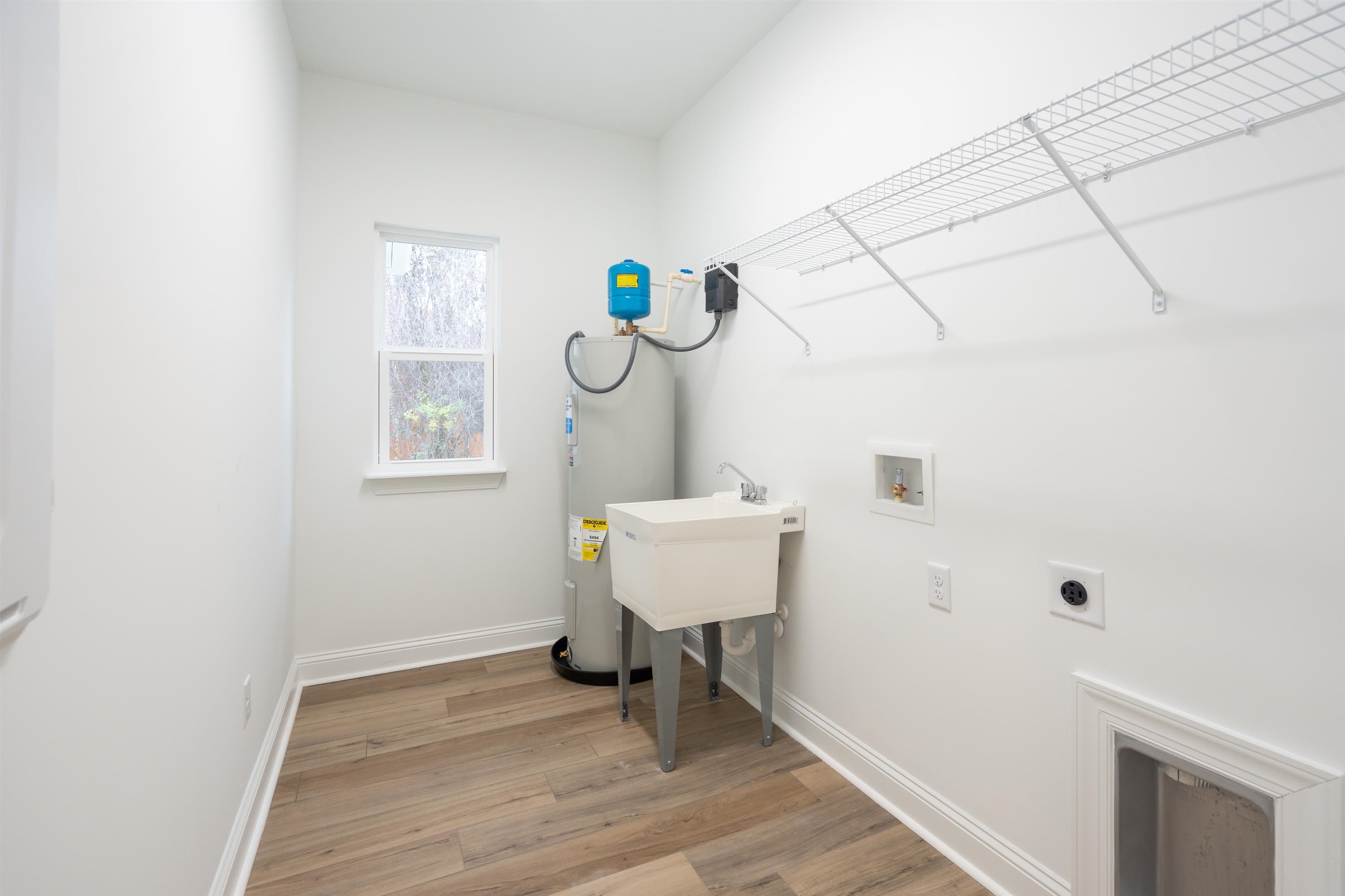 108 Aspen Road St. Augustine, FL 32086 - Photo 22 of 24 Washroom featuring light wood finished floors, electric water heater, hookup for a washing machine, and hookup for an electric dryer