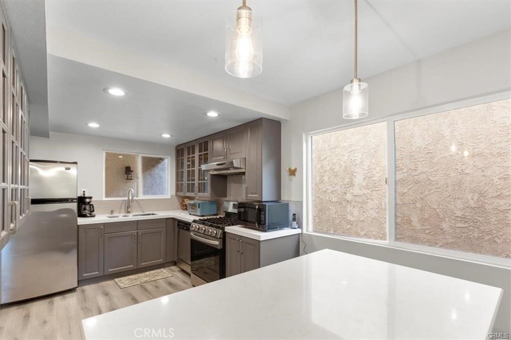 1353 Termino Avenue Long Beach, CA 90804 - Photo 11 of 30 a kitchen with stainless steel appliances kitchen island a sink a stove a refrigerator and cabinets