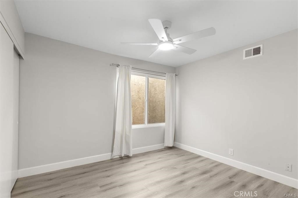 1353 Termino Avenue Long Beach, CA 90804 - Photo 15 of 30 an empty room with wooden floor fan and windows