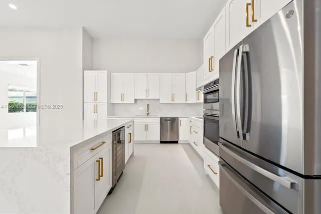 a kitchen with white cabinets and sink