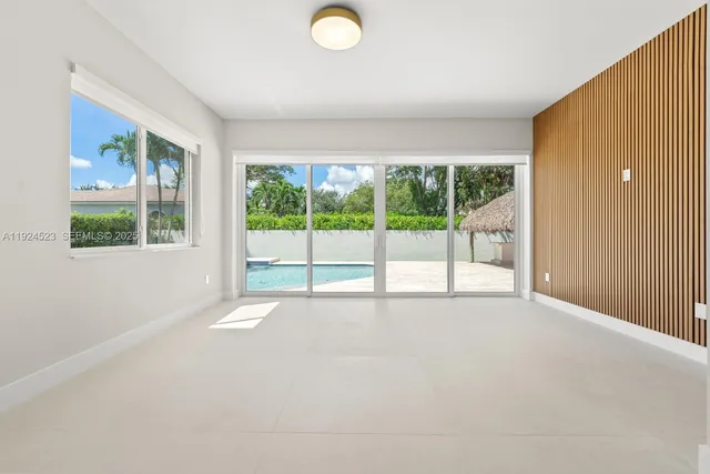 a view of an empty room with wooden floor and glass door