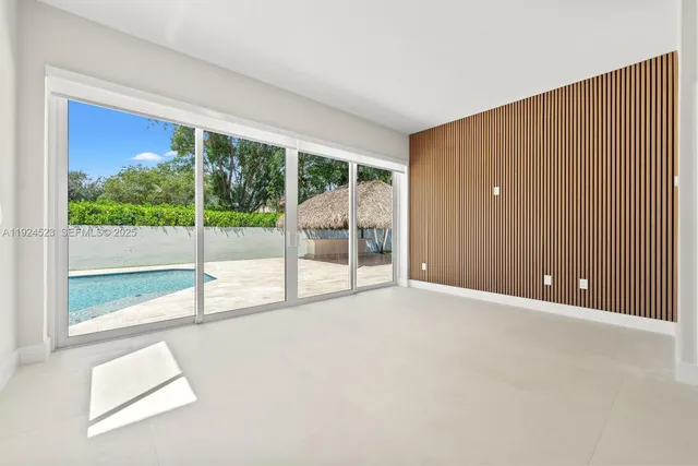 an empty room with wooden floor and glass door