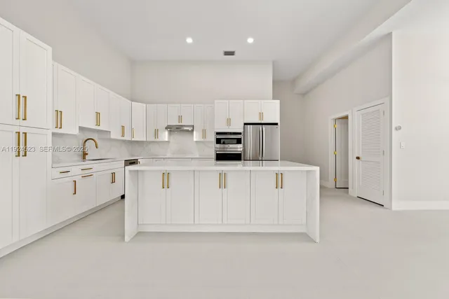 a kitchen with stainless steel appliances a refrigerator sink and cabinets