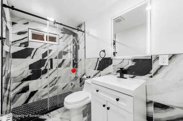 a bathroom with a sink toilet and shower