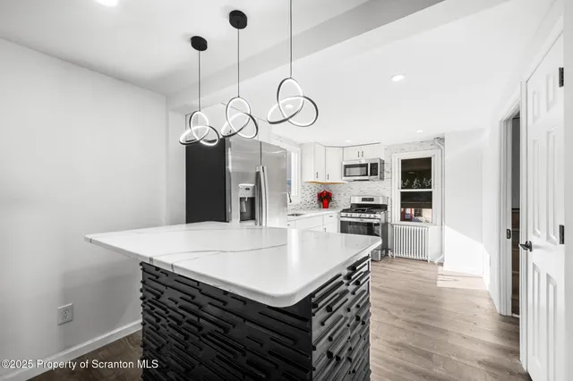a kitchen with a table chairs and wooden floor