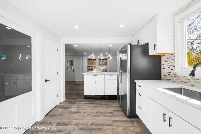 a kitchen with a sink a refrigerator and cabinets