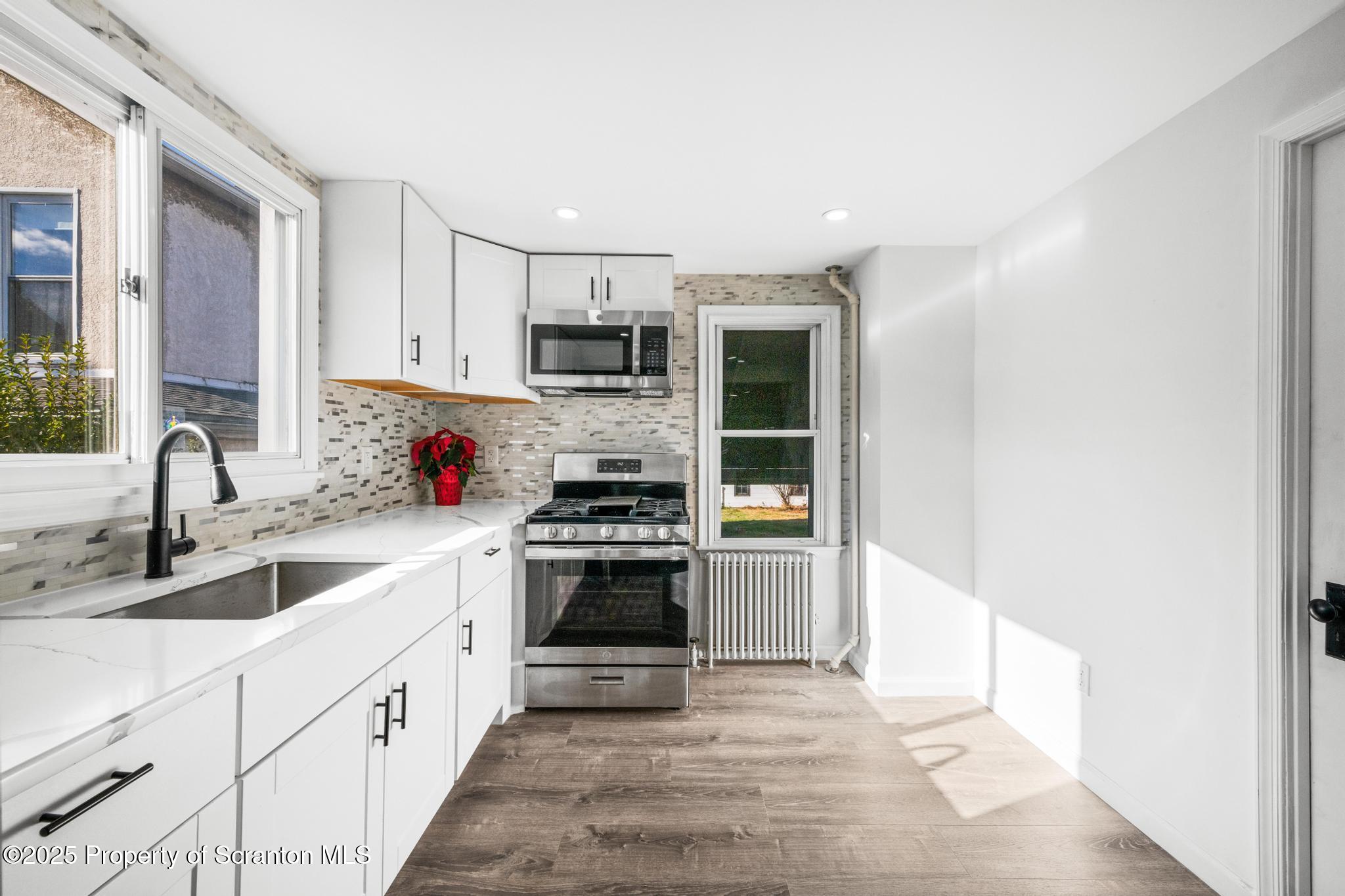 949 Taylor Avenue Scranton, PA 18510 - Photo 34 of 46 a kitchen with stainless steel appliances sink a stove and white cabinets