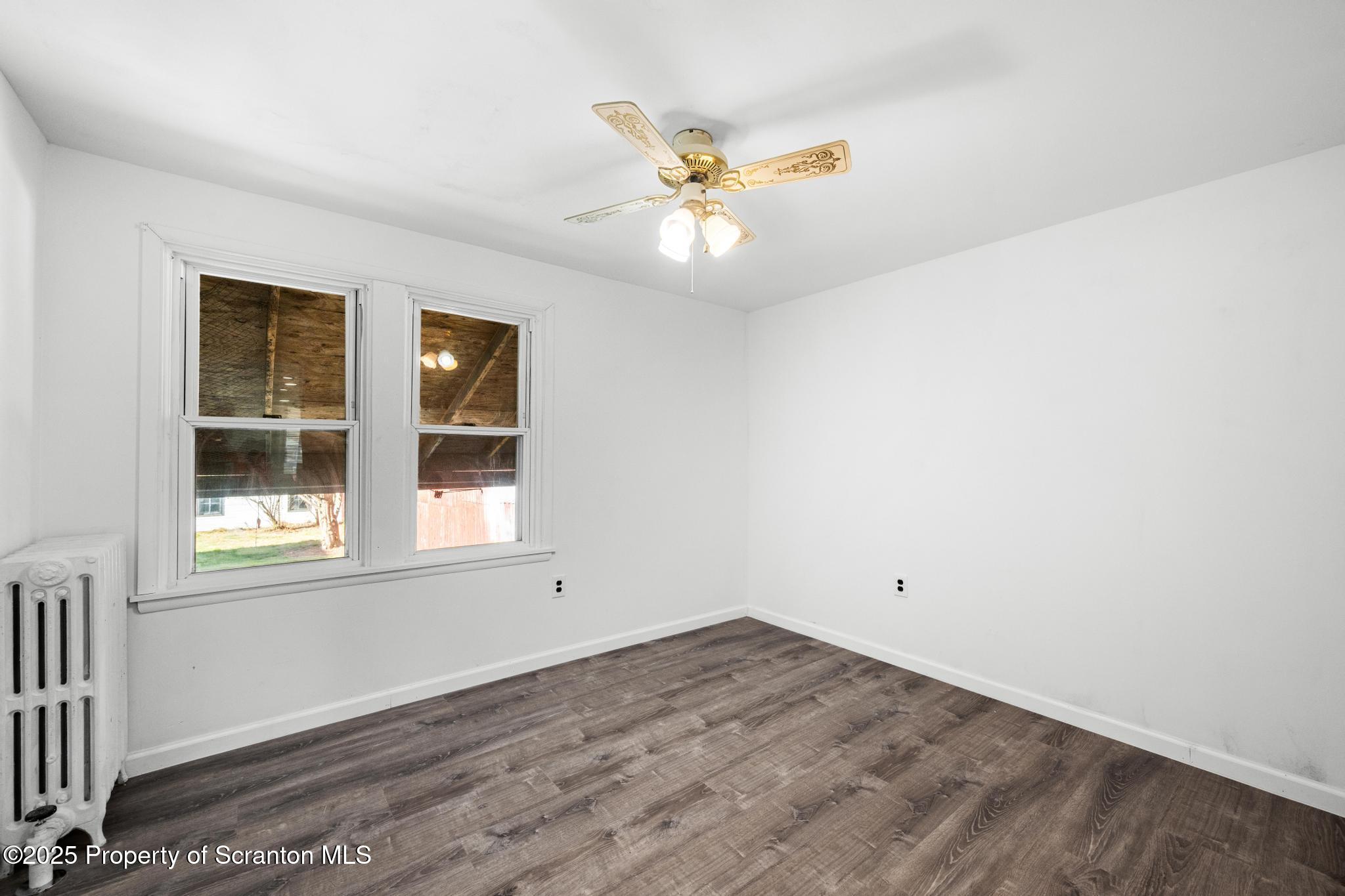 949 Taylor Avenue Scranton, PA 18510 - Photo 35 of 46 an empty room with wooden floor fan and windows