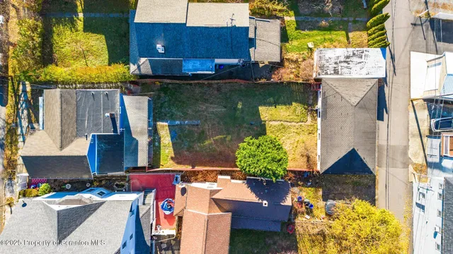 a aerial view of a house with swimming pool and large trees