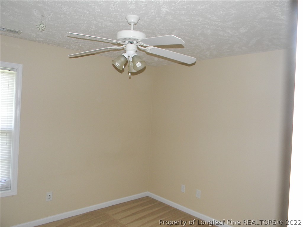 122 Middle Court Raeford, NC 28376 - Photo 16 of 23 a view of empty room with wooden floor and fan