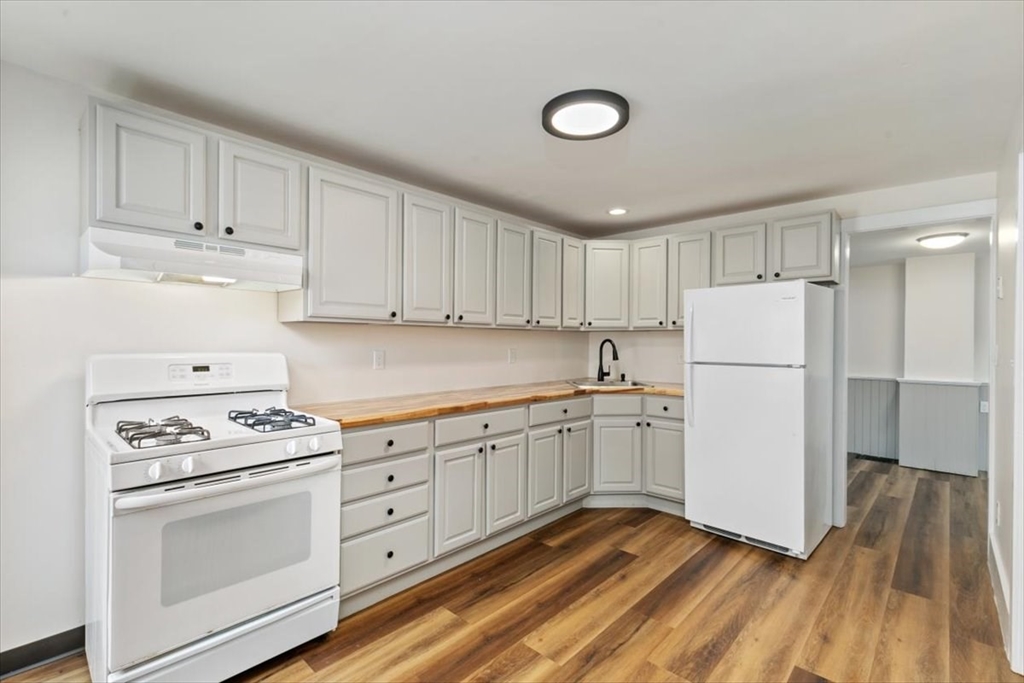 16 Rantoul Street Beverly, MA 01915 - Photo 11 of 34 a kitchen with granite countertop white cabinets and white appliances