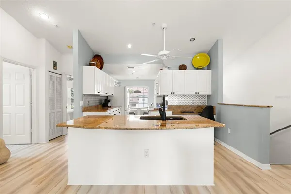 a kitchen with kitchen island granite countertop a sink a stove counter space and wooden floor