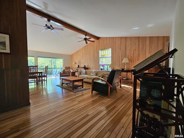 a living room with furniture a window and wooden floor